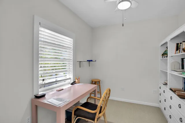 a view of a workspace with furniture and a window