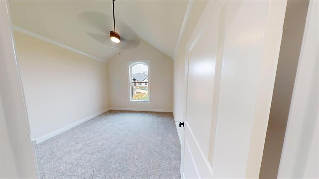 2509 Windmill Lane Longview, TX 75601 - Photo 13 of 35 Spare room featuring vaulted ceiling, light carpet, and a ceiling fan