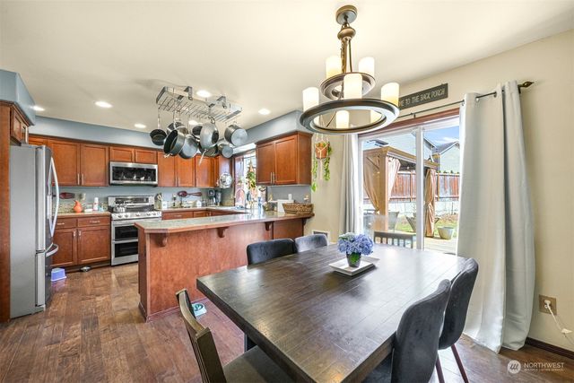 a kitchen with a dining table chairs stove and refrigerator