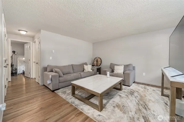 a living room with furniture and a wooden floor