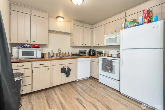 a kitchen with granite countertop white cabinets and white appliances