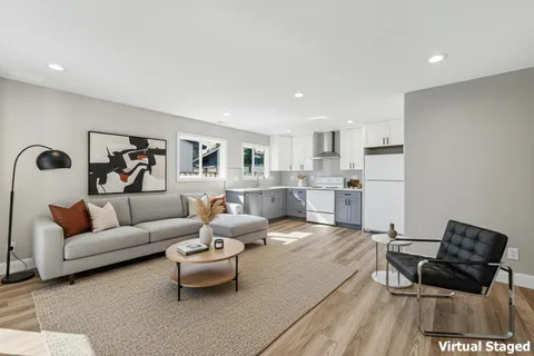 a living room with furniture and a wooden floor