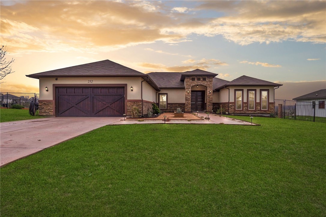 a front view of a house with a yard and trees