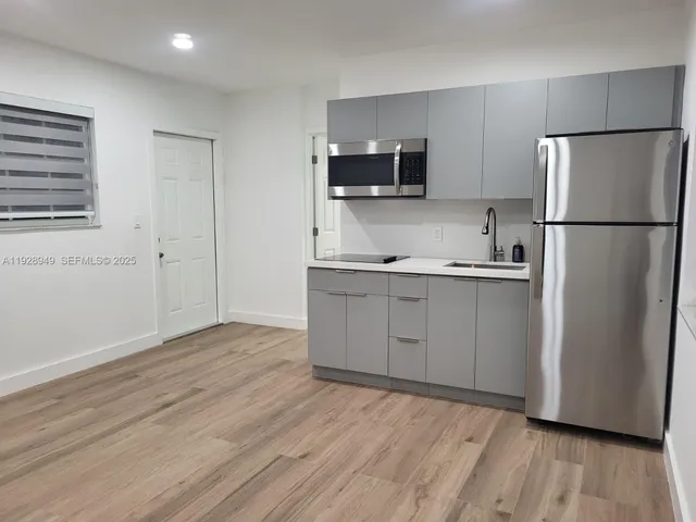 a kitchen with a refrigerator sink and cabinets