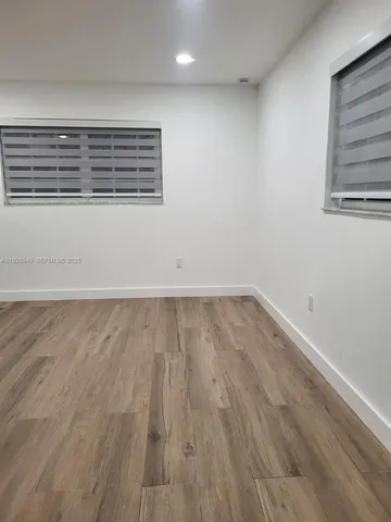 a view of a room with wooden floor and window