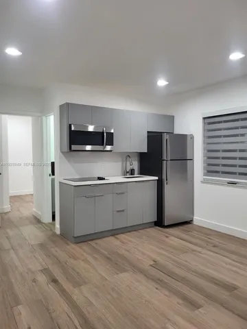 a kitchen with stainless steel appliances a refrigerator sink and microwave
