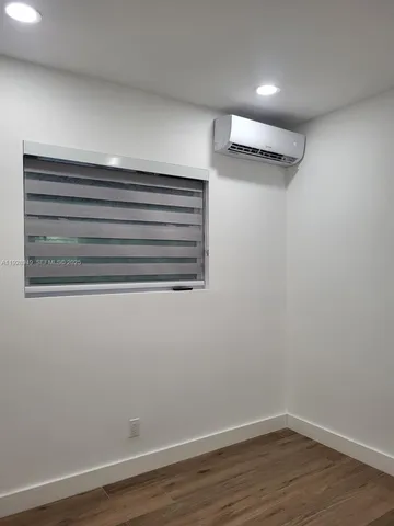 a view of a room with wooden floor and a window