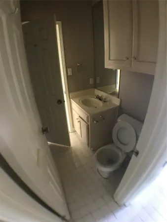 a bathroom with a toilet sink and mirror