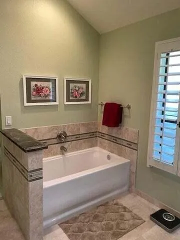 a spacious bathroom with a granite countertop tub and a sink