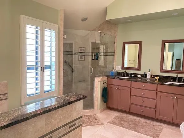 a spacious bathroom with a granite countertop tub sink and mirror