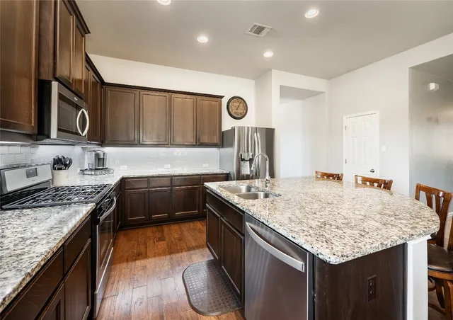 a kitchen with a stove sink and cabinets