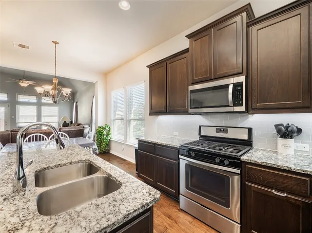 a kitchen with granite countertop a sink and steel appliances