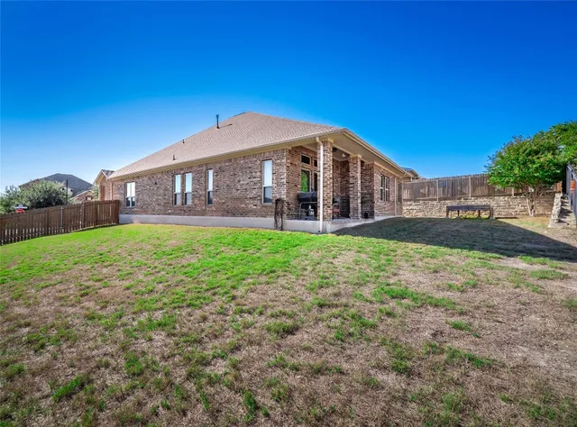 a view of a house with a yard and sitting area