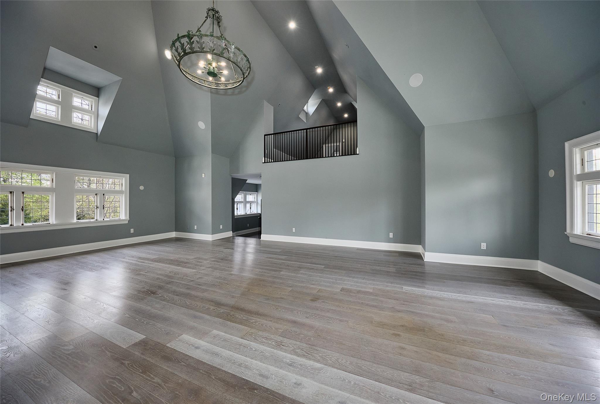 76 Summit Road Tuxedo Park, NY 10987 - Photo 19 of 37 an empty room with wooden floor chandelier and windows