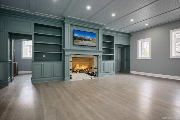 a view of a livingroom with wooden floor a fireplace and window
