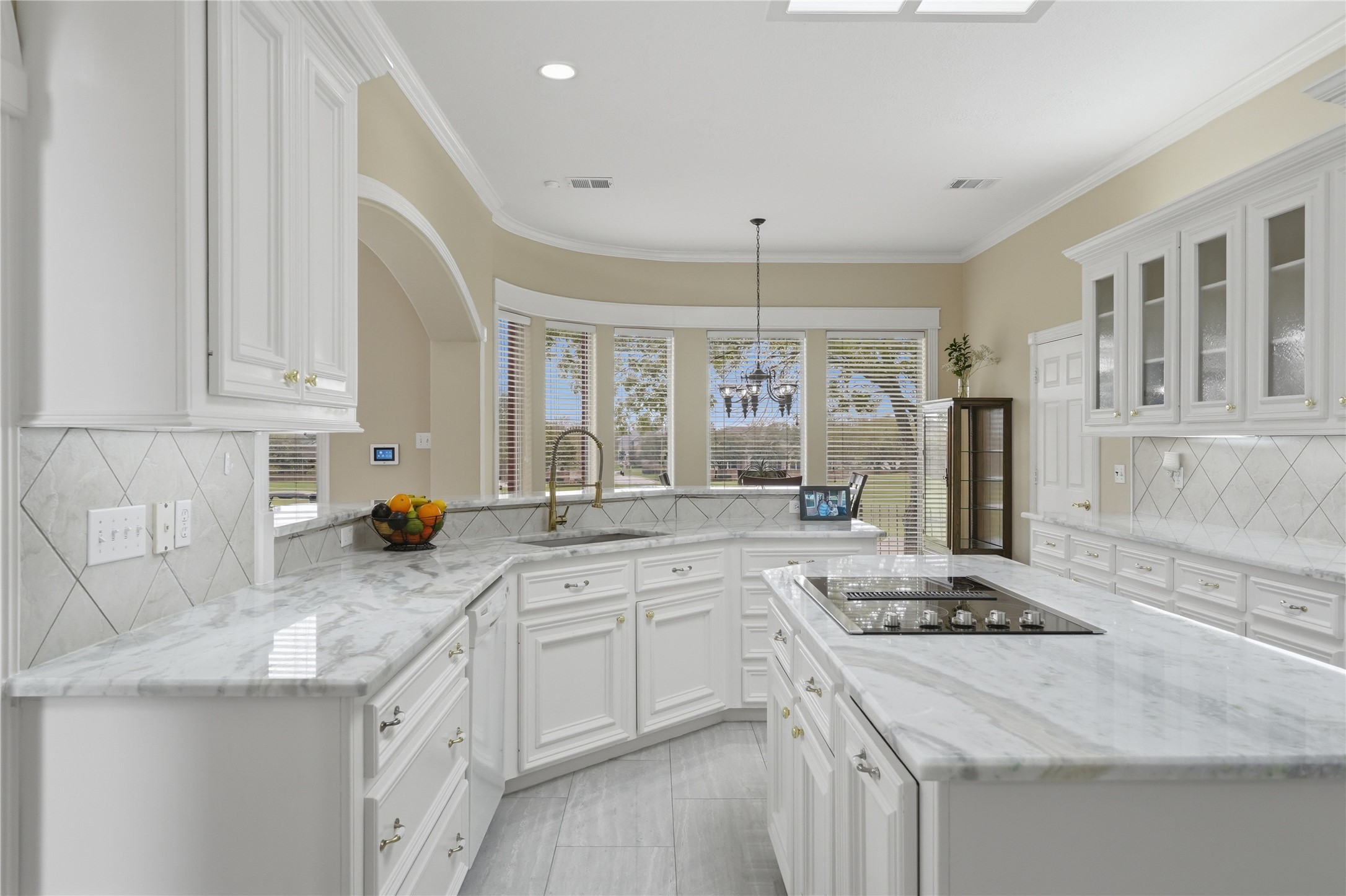 55 Monterrey Road East Montgomery, TX 77356 - Photo 17 of 50 Bright and spacious kitchen with elegant white cabinetry, marble countertops, and a modern cooktop island. Large windows provide natural light