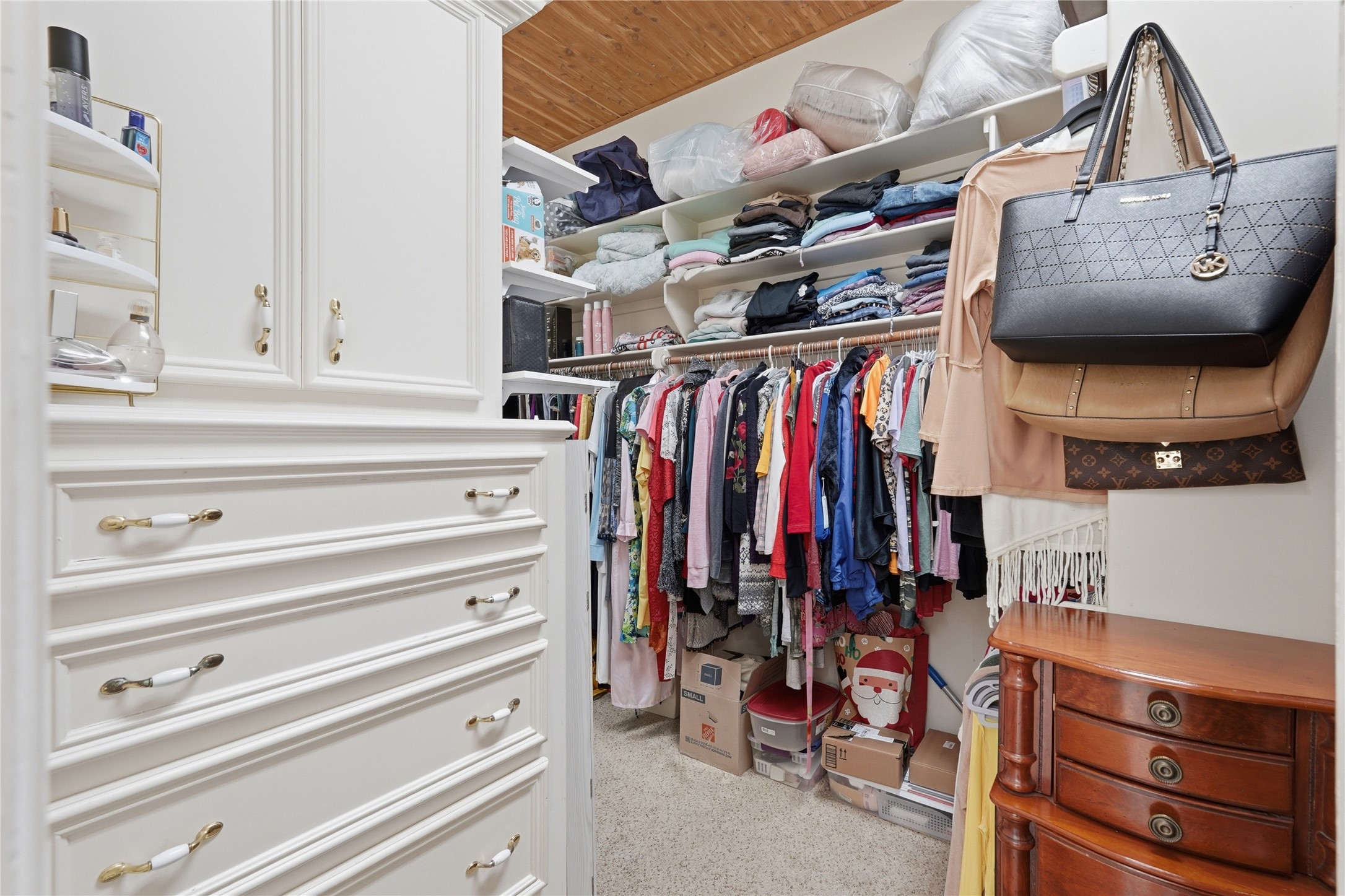 55 Monterrey Road East Montgomery, TX 77356 - Photo 27 of 50 This photo showcases a spacious walk-in closet with ample shelving and hanging space. It features built-in white cabinetry with brass handles.
