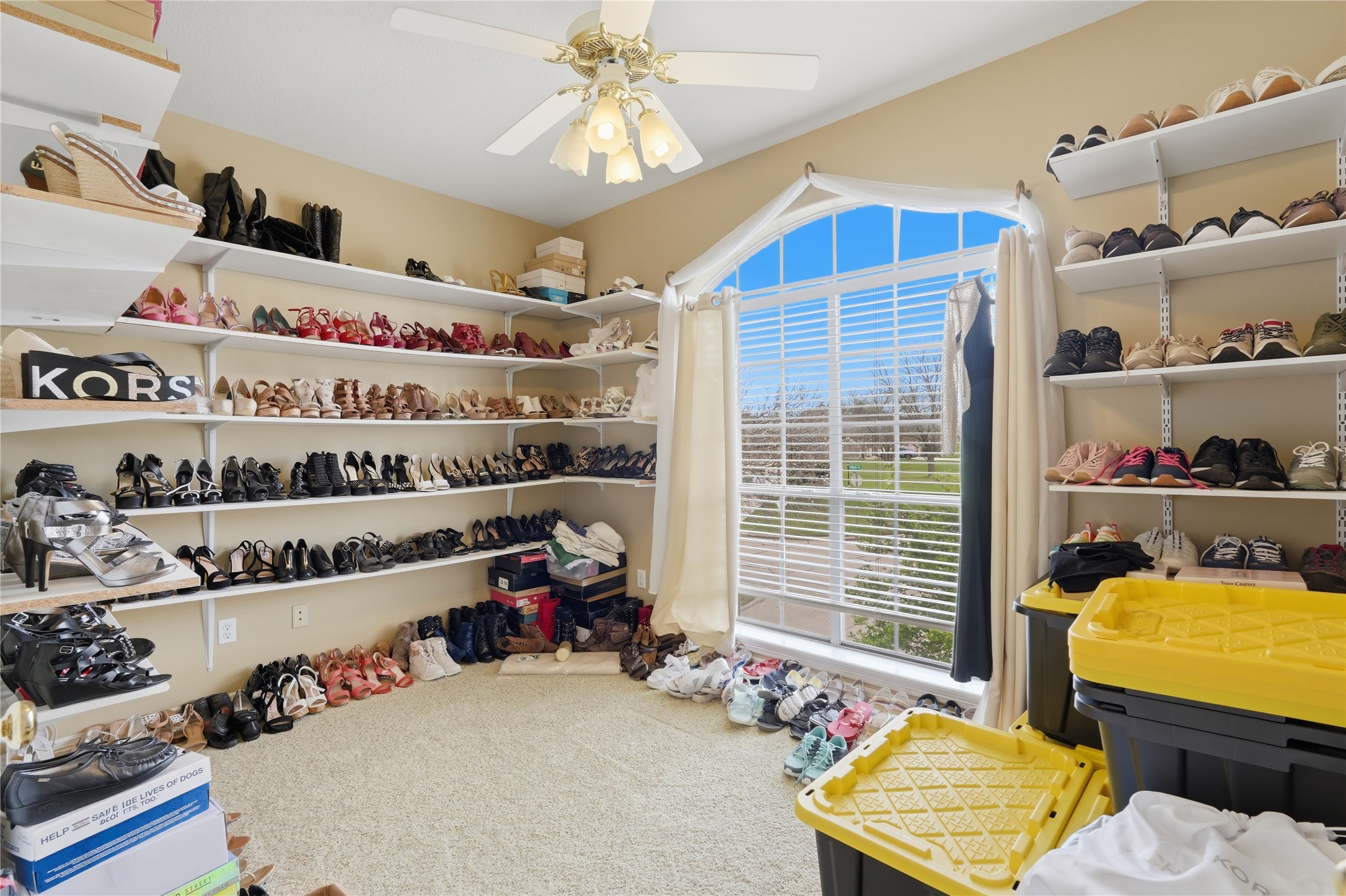 55 Monterrey Road East Montgomery, TX 77356 - Photo 28 of 50 This spacious walk-in closet features ample shelving for shoes and accessories, a large window providing natural light, and a ceiling fan for comfort. Ideal for organizing and displaying your wardrobe.