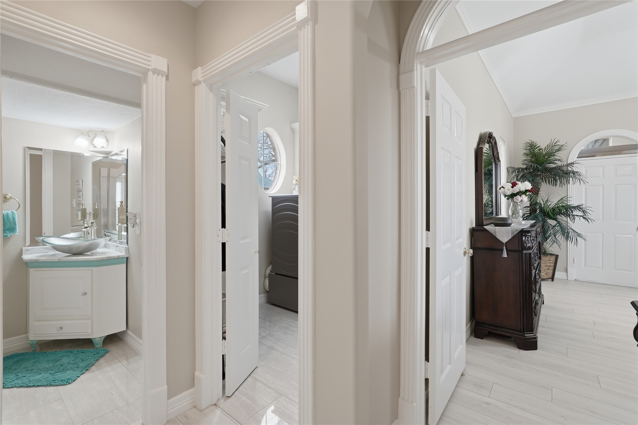55 Monterrey Road East Montgomery, TX 77356 - Photo 38 of 50 This photo showcases a bright, well-lit hallway with light-colored walls and flooring. It features a bathroom with a modern vanity, and a glimpse into a stylish room. The overall feel is clean and inviting.