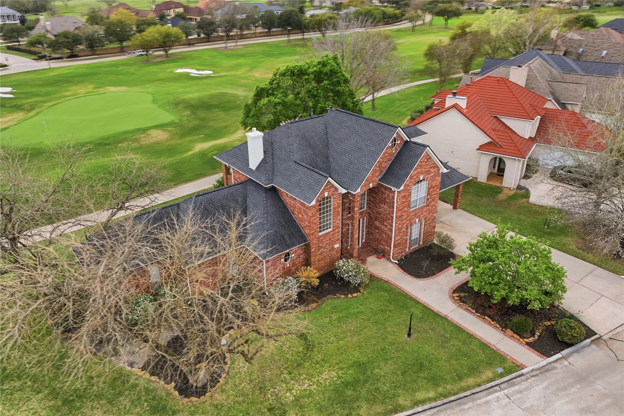 55 Monterrey Road East Montgomery, TX 77356 - Photo 50 of 50 This charming brick home features a well-maintained lawn and is situated next to a golf course, offering scenic views and a spacious driveway. Ideal for those seeking a serene and picturesque setting.