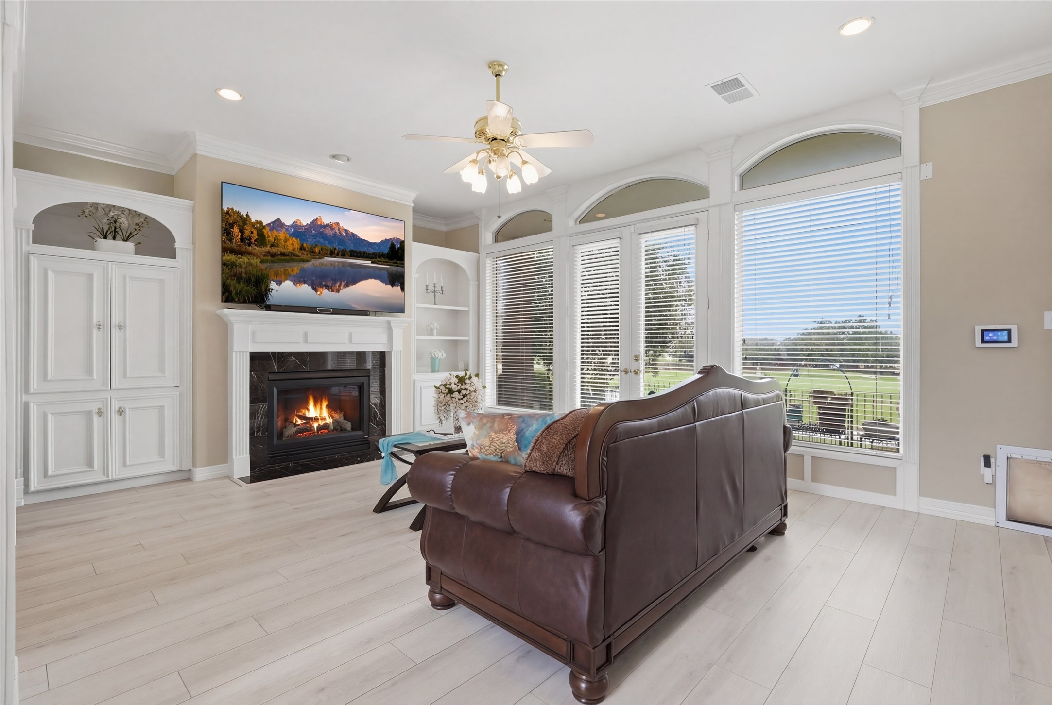 55 Monterrey Road East Montgomery, TX 77356 - Photo 10 of 50 This inviting living room features a cozy fireplace with an elegant built-in cabinetry, and large windows offering plenty of natural light and scenic views.