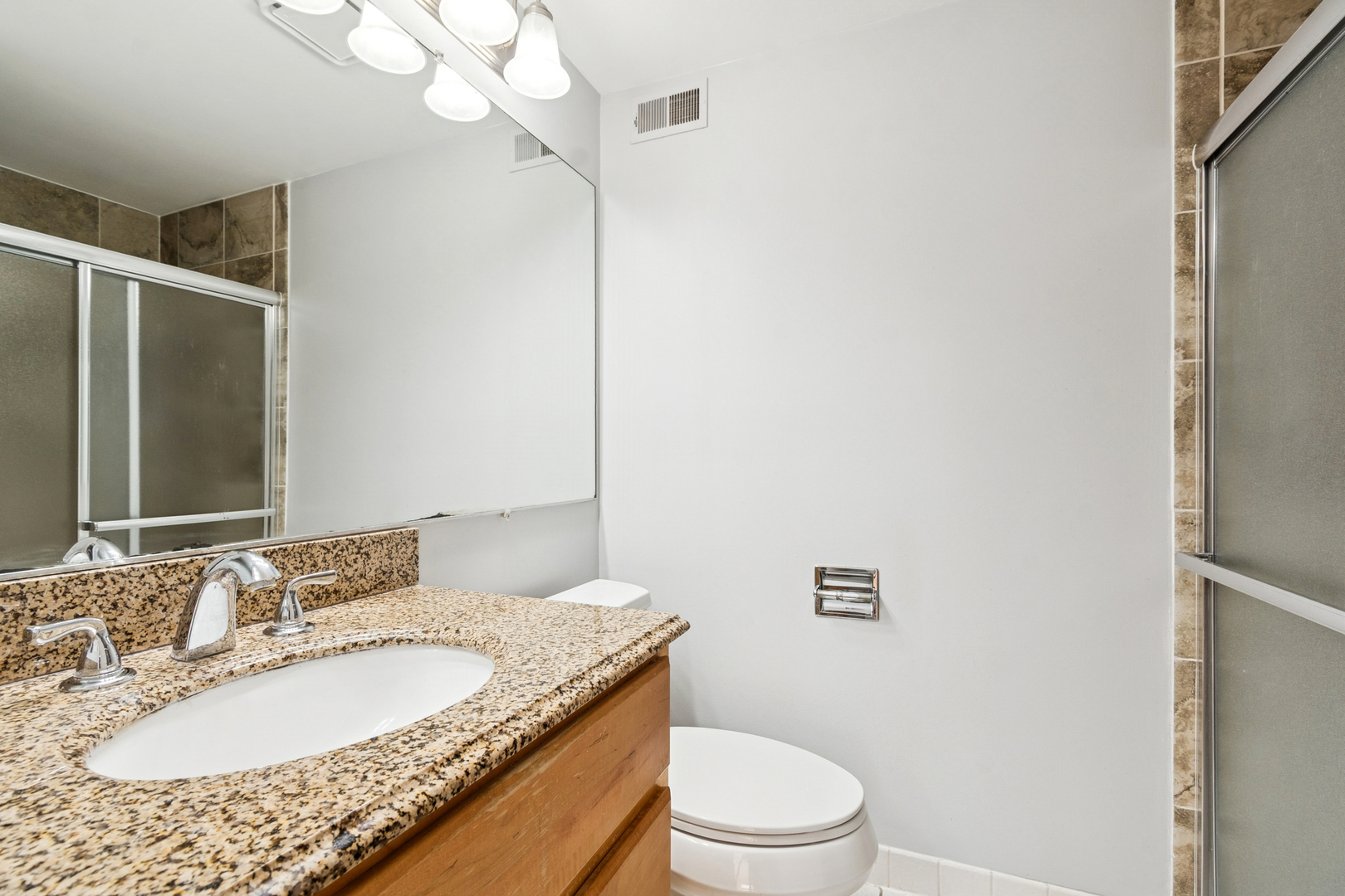 33 Shoreline Road, Unit B Lake Barrington, IL 60010 - Photo 27 of 49 a bathroom with a granite countertop sink a toilet and a mirror