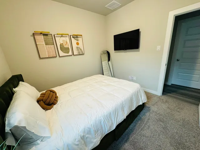 a bedroom with a bed a couch and a window