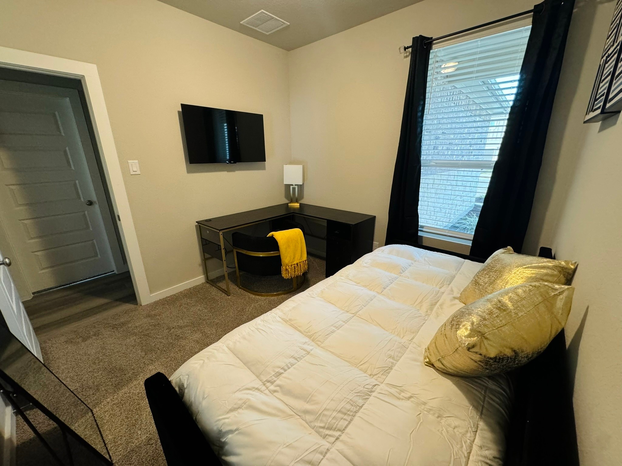 5608 Madden Lane Houston, TX 77048 - Photo 21 of 29 a bedroom with a bed and a flat tv screen on a dresser
