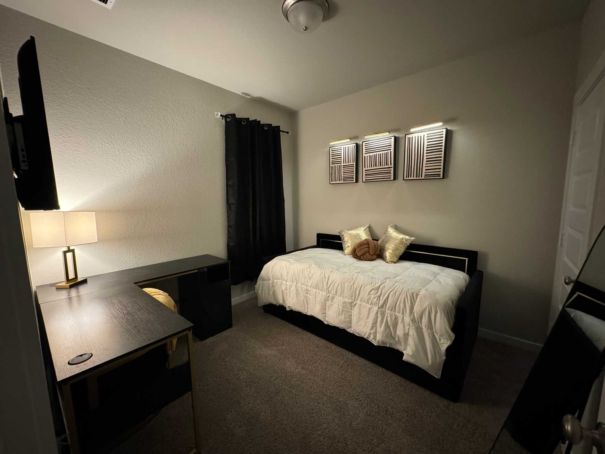 5608 Madden Lane Houston, TX 77048 - Photo 27 of 29 a bedroom with a bed and a flat tv screen on a dresser