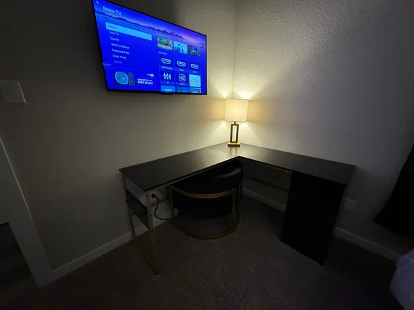 a bedroom with a bed and a flat tv screen on a dresser