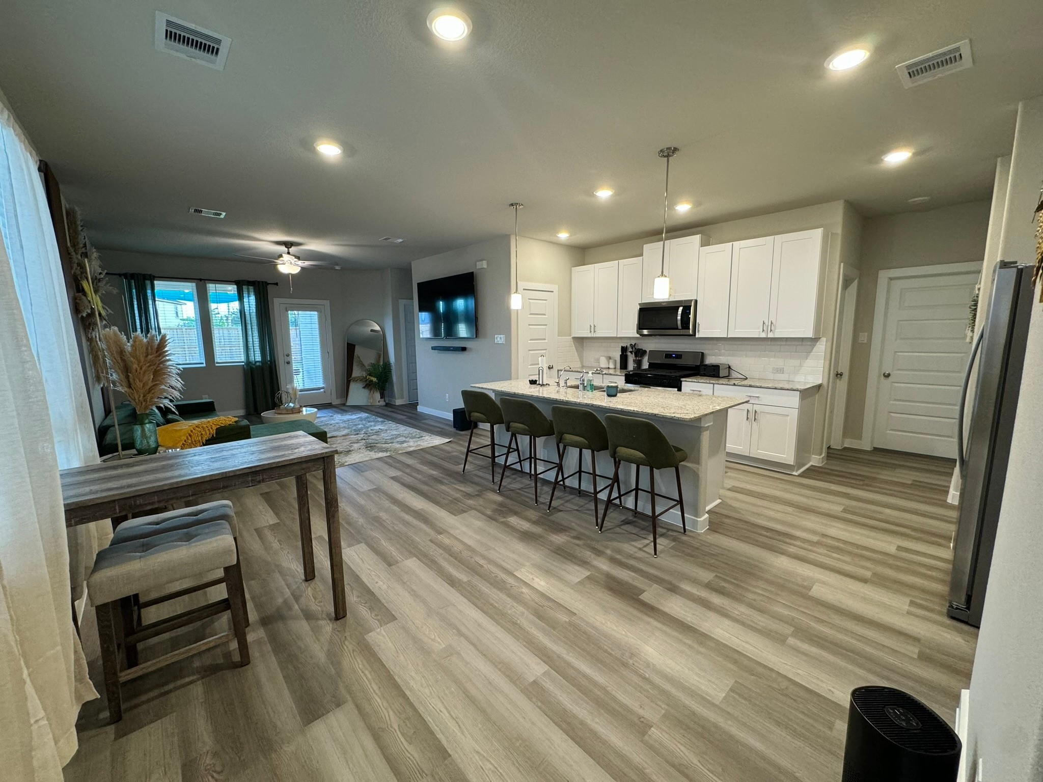 5608 Madden Lane Houston, TX 77048 - Photo 5 of 29 a view of a kitchen with kitchen island a dining table chairs stainless steel appliances and cabinets