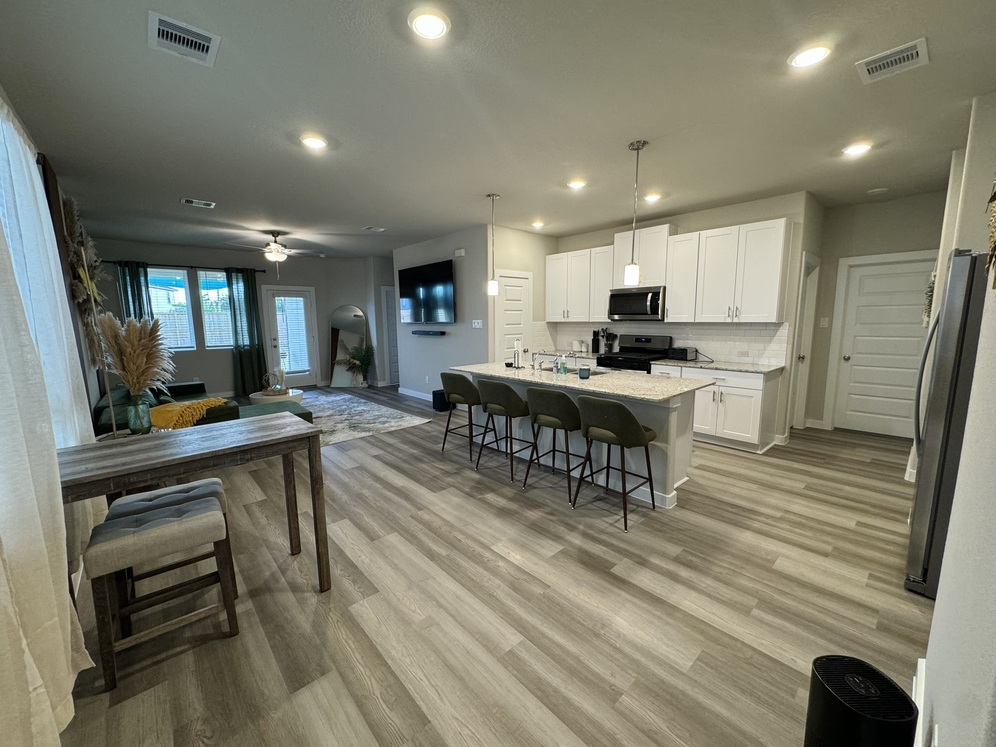 5608 Madden Lane Houston, TX 77048 - Photo 5 of 29 a view of a kitchen with kitchen island a dining table chairs stainless steel appliances and cabinets