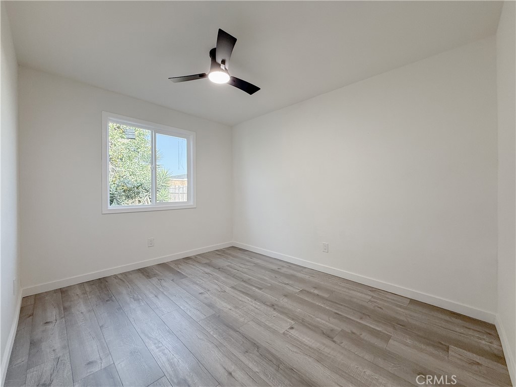 521 West Cherry Street Compton, CA 90222 - Photo 18 of 20 an empty room with wooden floor chandelier fan and windows