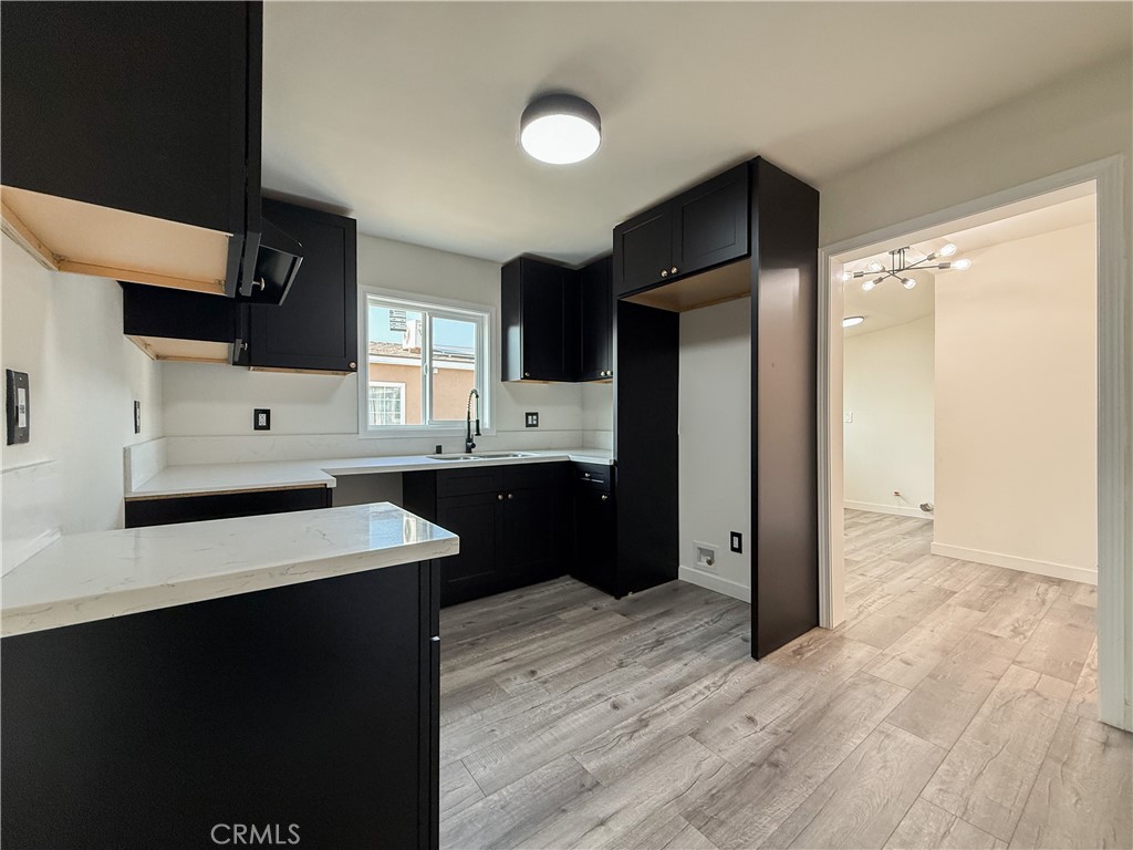 521 West Cherry Street Compton, CA 90222 - Photo 7 of 20 a kitchen with stainless steel appliances kitchen island granite countertop a refrigerator a sink and dishwasher with wooden floor