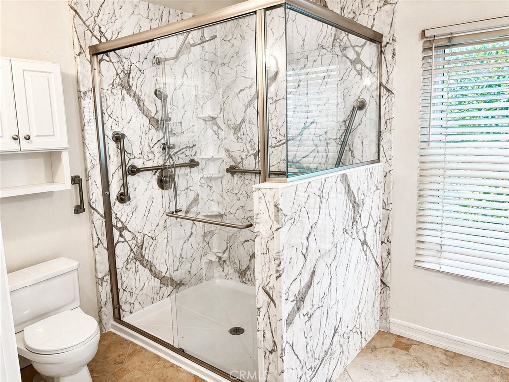 117 East Yale Loop, Unit 24 Irvine, CA 92604 - Photo 10 of 13 a bathroom with a shower curtain and a toilet
