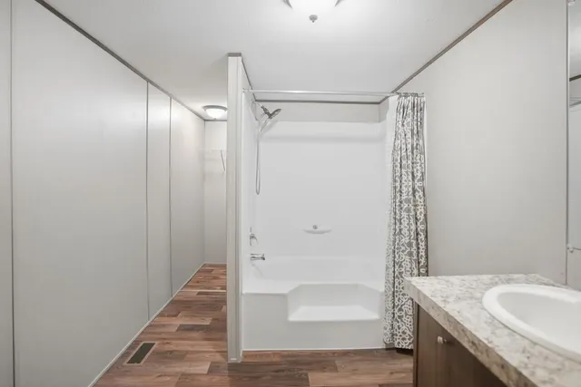 a bathroom with a granite countertop sink and shower