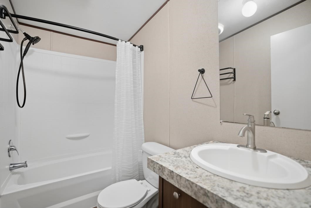553 Jennifer Loop Orange Grove, TX 78372 - Photo 21 of 30 a bathroom with a granite countertop sink toilet and shower