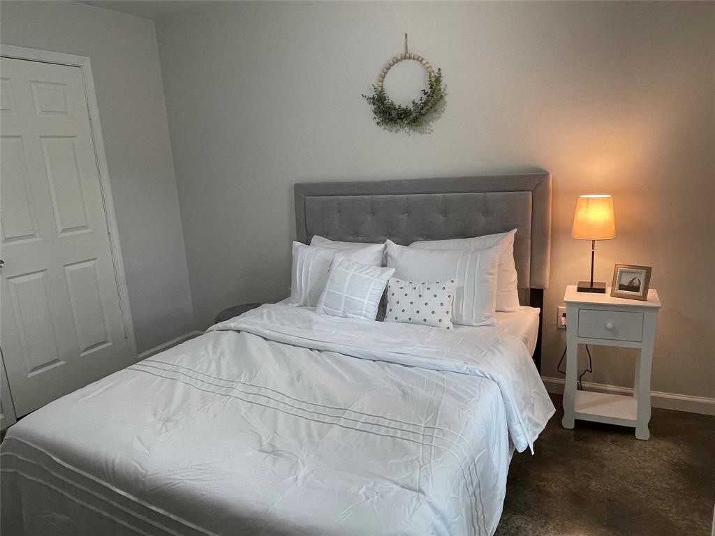 635 Martin Luther King Road Ames, TX 77575 - Photo 18 of 20 a bedroom with a bed and a chandelier