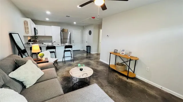 a living room with furniture and kitchen view