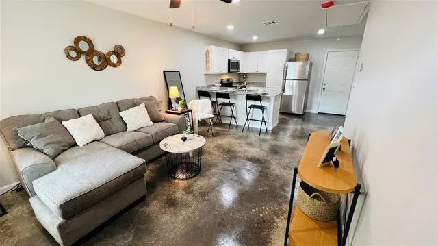a living room with furniture and a wooden floor