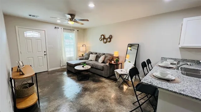 a living room with furniture and a chandelier