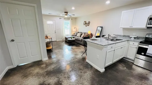 a living room with furniture a sink and a stove