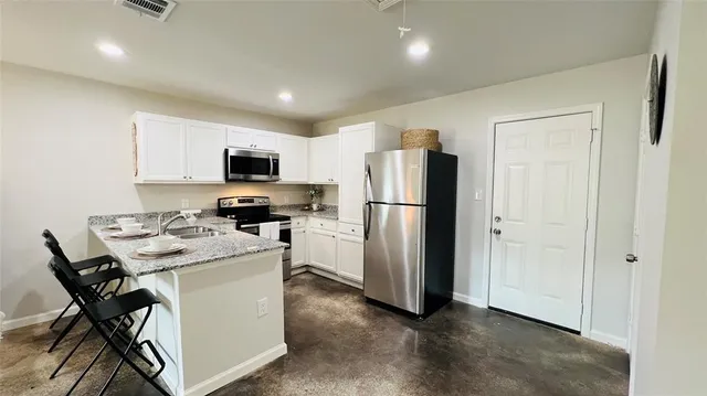 a kitchen with a refrigerator a microwave a stove and a dining table