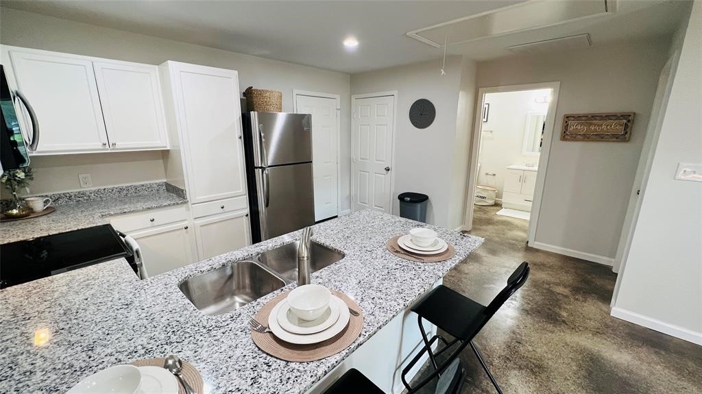 635 Martin Luther King Road Ames, TX 77575 - Photo 10 of 20 a kitchen with sink refrigerator dining table and chairs