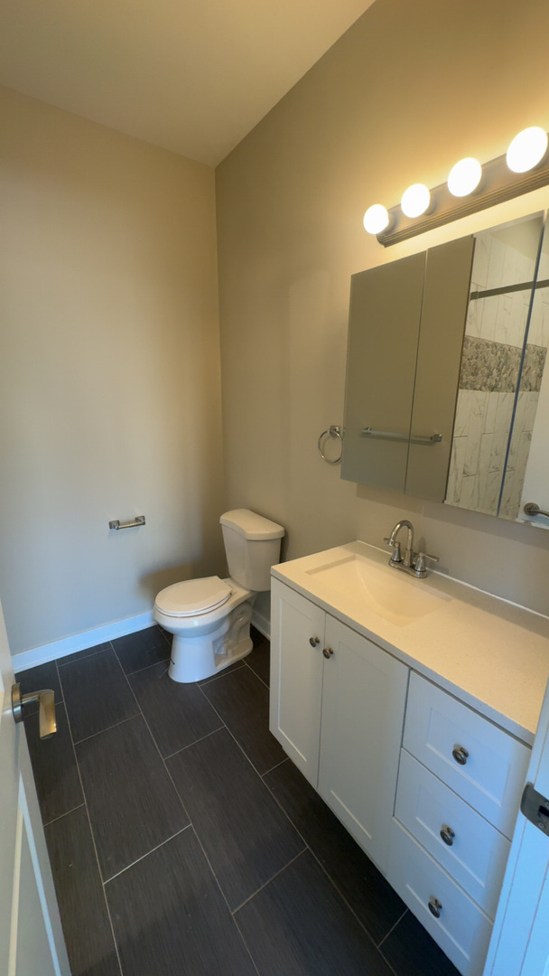 22 North Parkside Avenue, Unit 1 Chicago, IL 60644 - Photo 11 of 13 a bathroom with a toilet sink and mirror