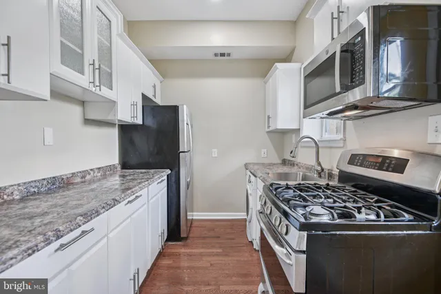 a kitchen with stainless steel appliances granite countertop a stove and a sink