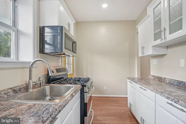 a kitchen with stainless steel appliances granite countertop a sink and a stove
