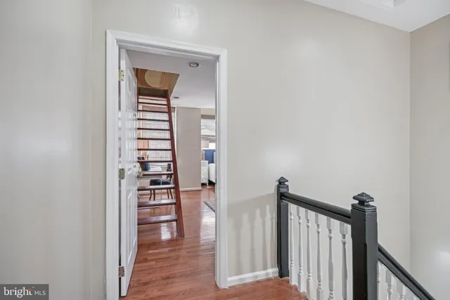 a view of a hallway with wooden floor and stairs