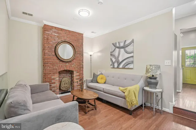 a living room with furniture a fireplace and a wooden floor