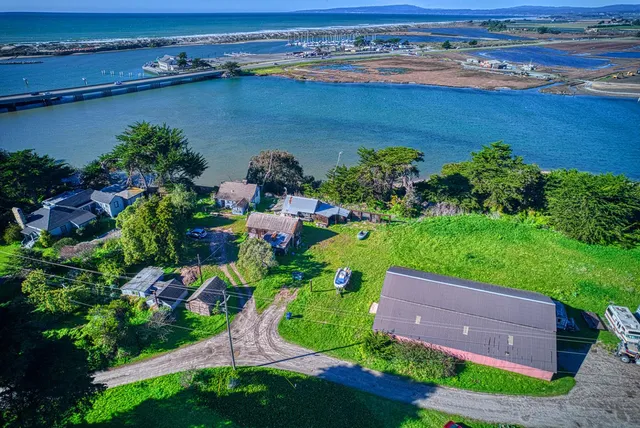 an aerial view of a house with a yard and lake view